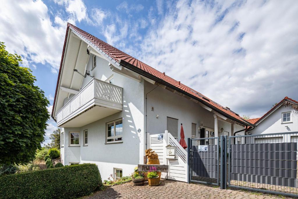 a white house with a gate and a fence at Sandhasen in Lauterbach
