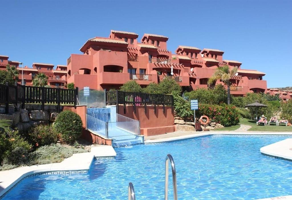 a swimming pool in front of a large building at Duplex apartment Estepona in Estepona