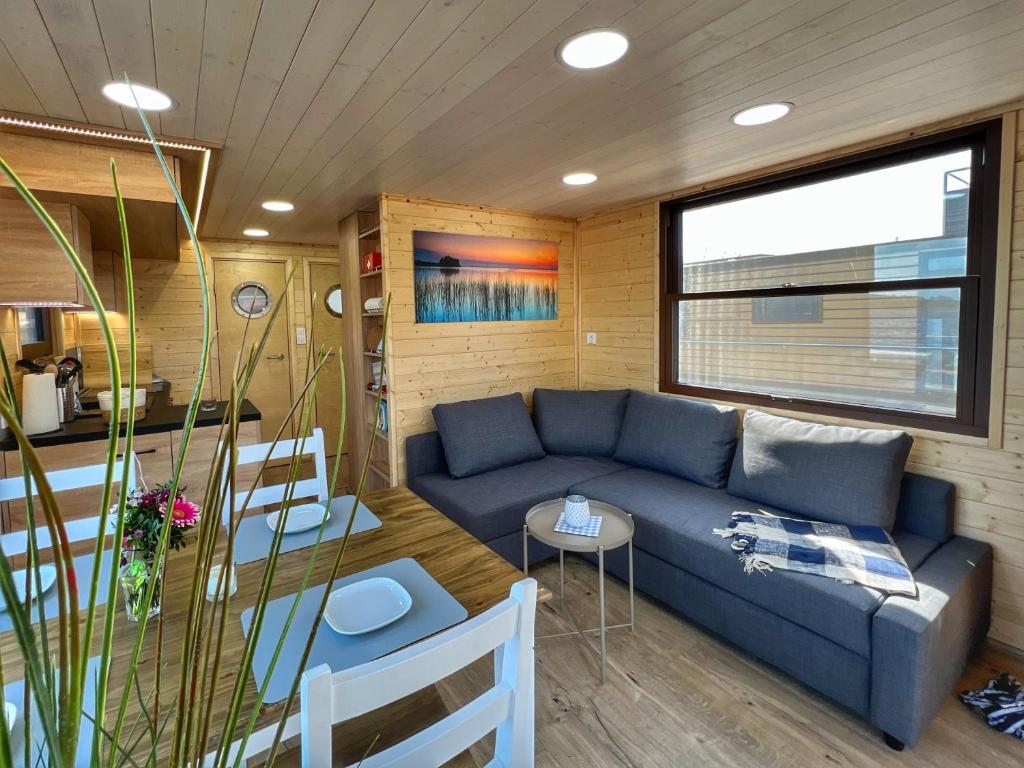 a living room with a blue couch and a table at Gemütliches Hausboot Seeliebe Woma in Fürstenberg