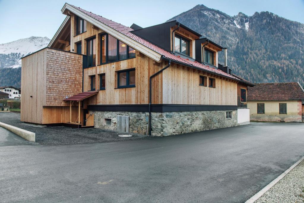 a house on a street with mountains in the background at Apartement Ben´s Auszeit Top 4 in Umhausen