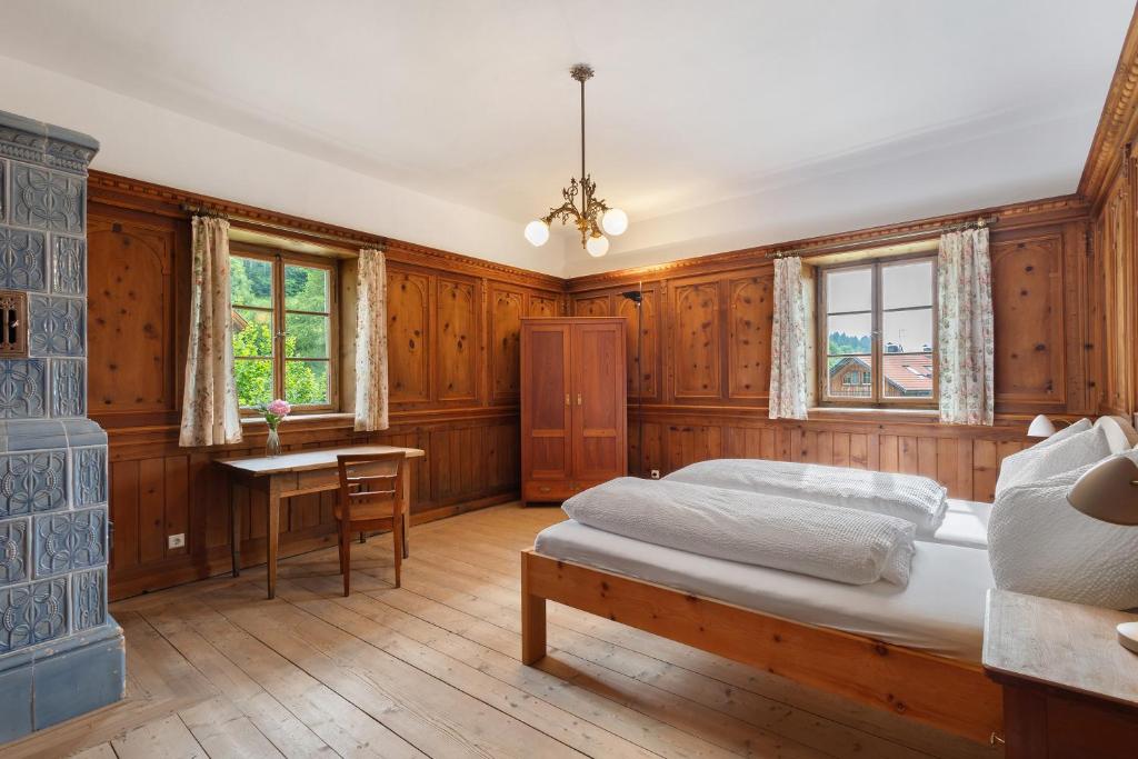 a bedroom with wooden walls and a bed and a fireplace at Ansitz Baumannhof Apt Erker Suite in Falzes