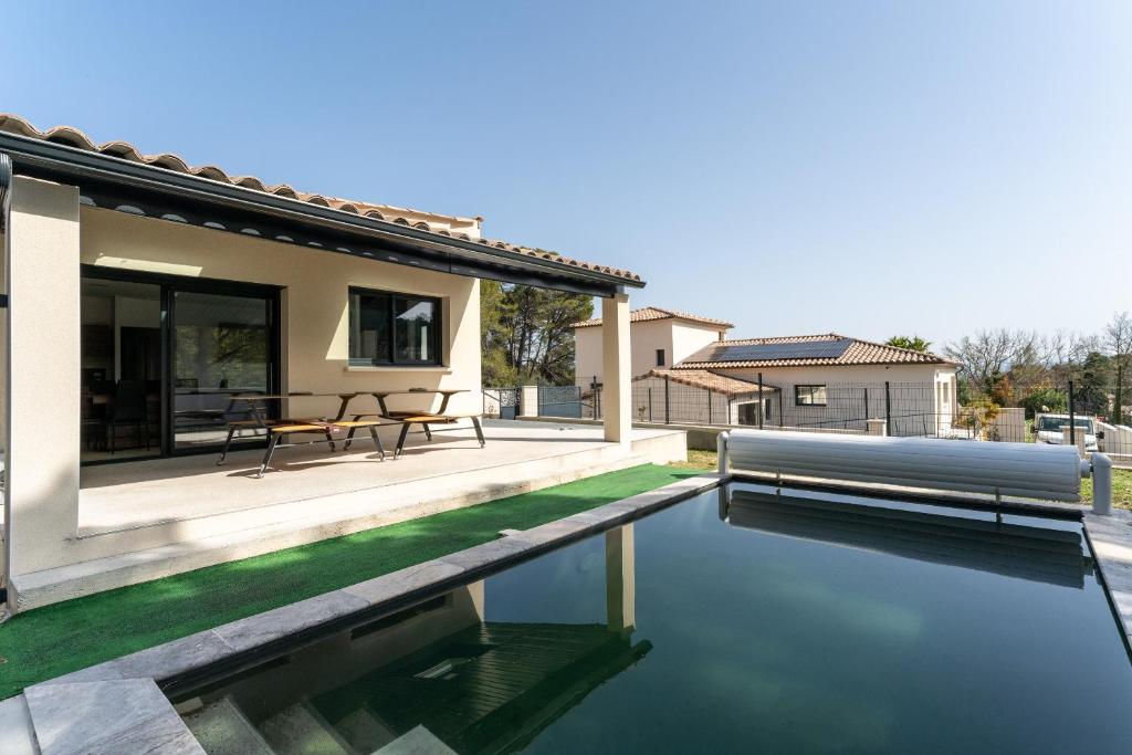 a house with a swimming pool next to a house at Villa Sérénity 10 pers maxi in Mondragon