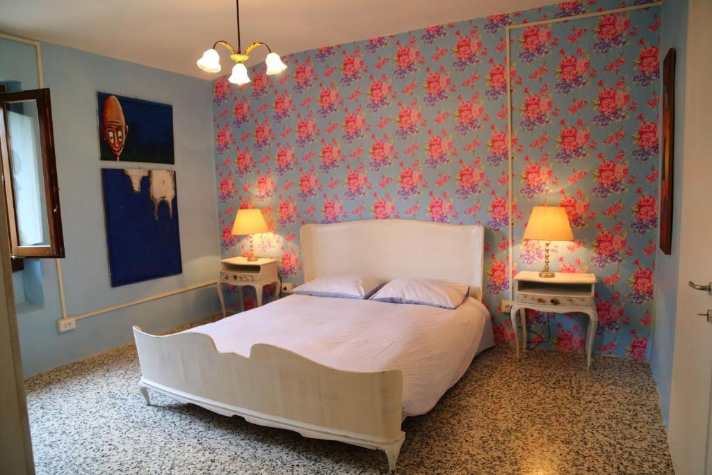 a bedroom with a bed and two tables with lamps at Re Piano appartamento Le Colline in Modigliana