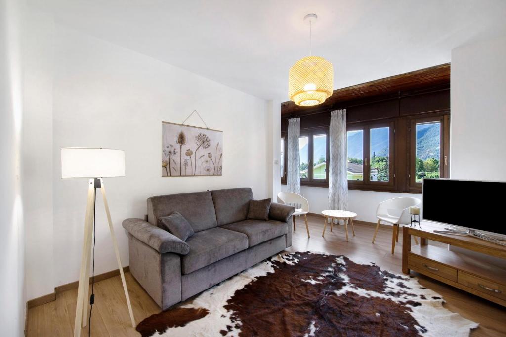 ein Wohnzimmer mit Sofa und Fernseher in der Unterkunft Chez Sabrina in Champdepraz