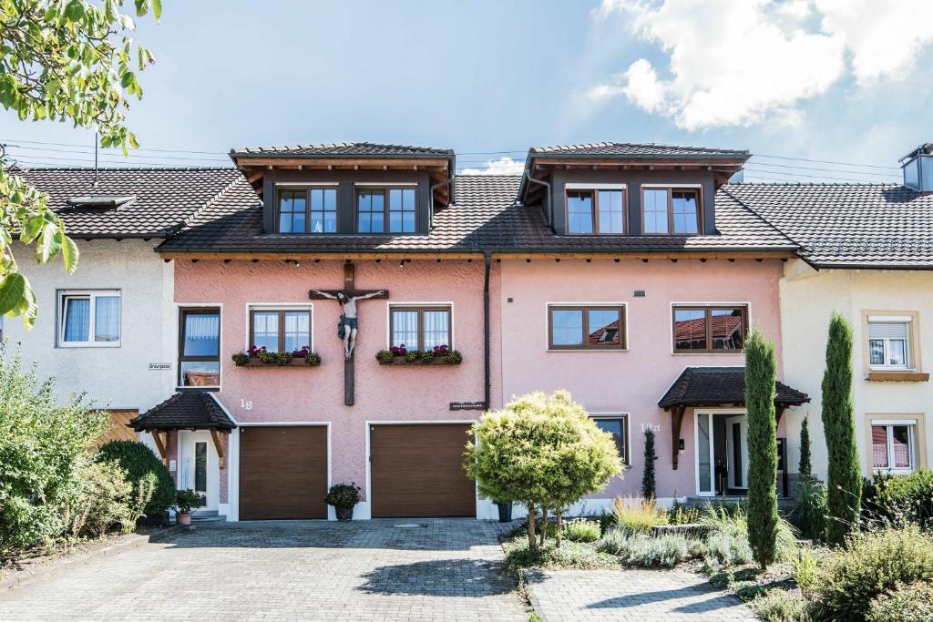 a large pink house with a garage at Ferienwohnung Heilsbergblick in Hilzingen