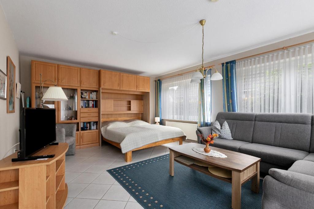 a living room with a couch and a bed at Haus Gartenidylle in Wesselburen