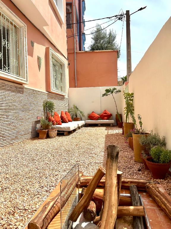 a courtyard of a building with a bench and plants at Tiri Hub in Tamraght Ouzdar