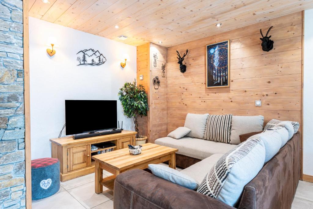 a living room with a couch and a tv at Gîte L'attrape Rêves in Bessans