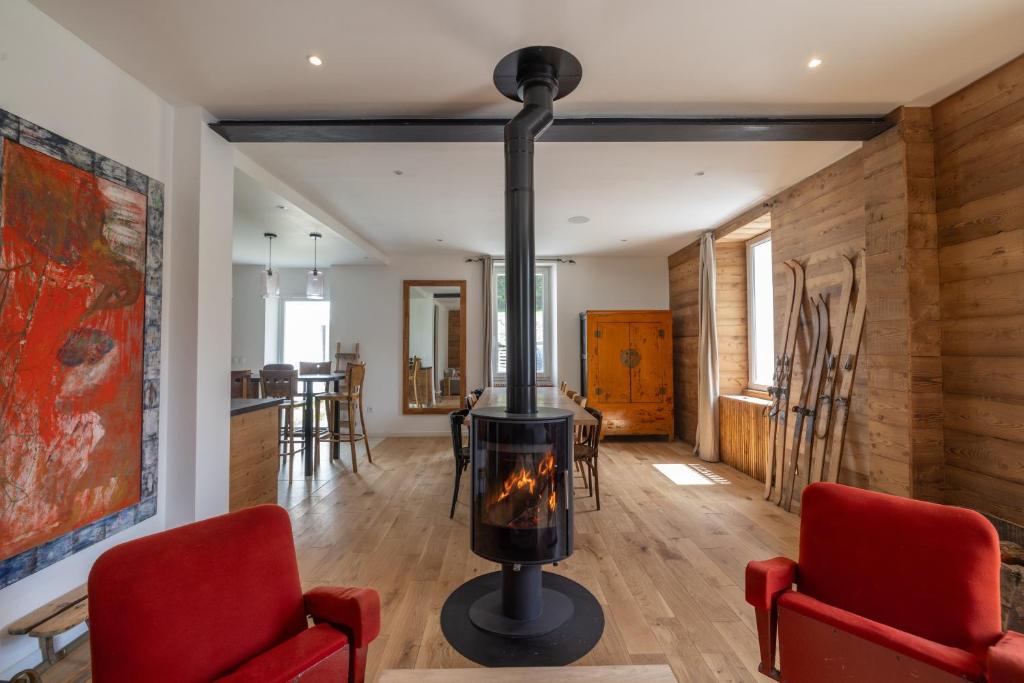 a fireplace in a living room with two red chairs at Chalet La Llyre Vallorcine in Vallorcine