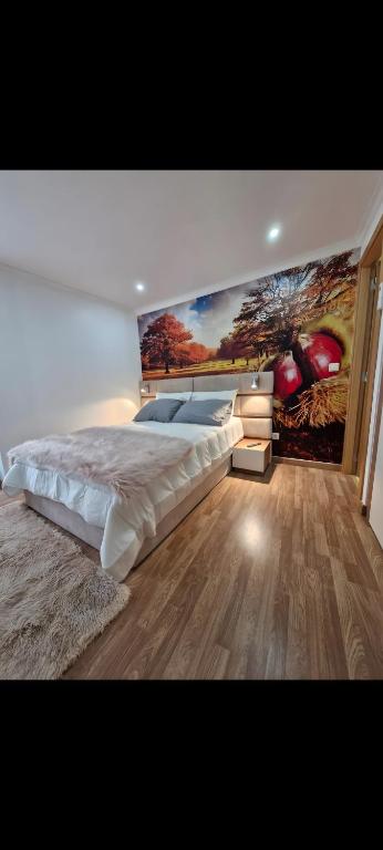 a bedroom with a large bed and a painting on the wall at Origens - Alojamento Local in Bragança