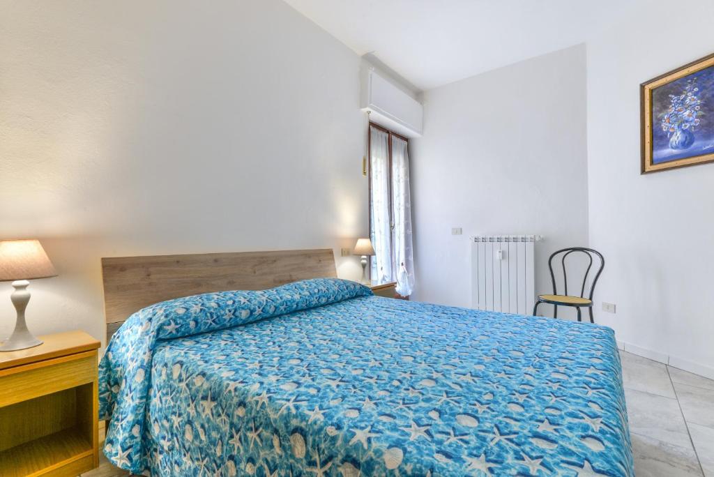 a bedroom with a bed and a table and a chair at Casa Claudia a Porto Azzurro in Porto Azzurro