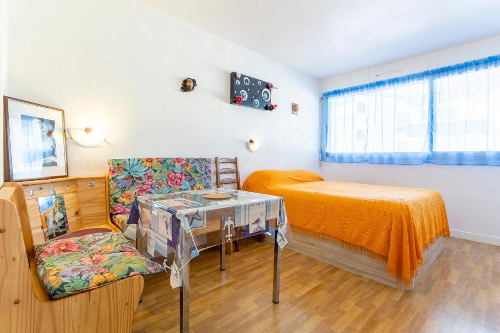 a bedroom with a bed and a table and a chair at Studio Turquoise à 100m de la plage in Bénodet