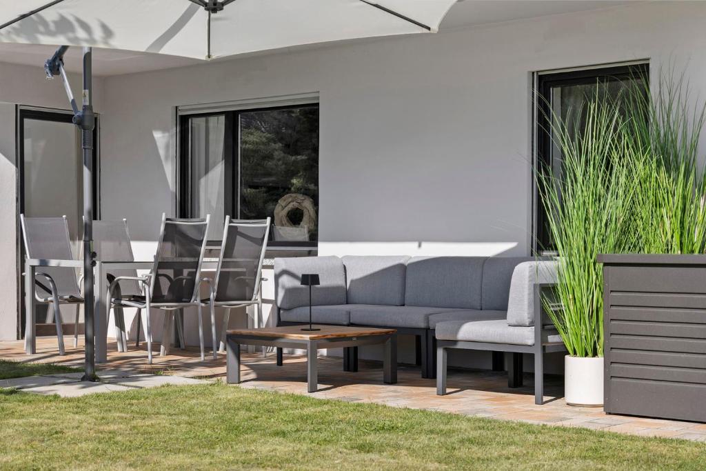 a patio with a couch and chairs and a table at Ferienwohnung Mayer in Albstadt
