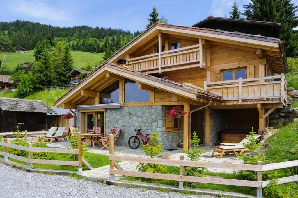 a log cabin with a porch and a fence at Chalet Pesse in Manigod
