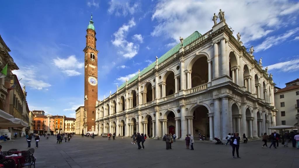 a large building with a clock tower in front of it at Apartments San Biagio in Vicenza