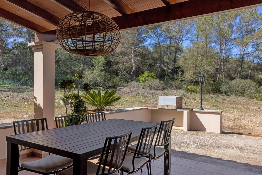 a table and chairs on a patio with a chandelier at Ca N'Alicia Des Bosch in Illes Balears