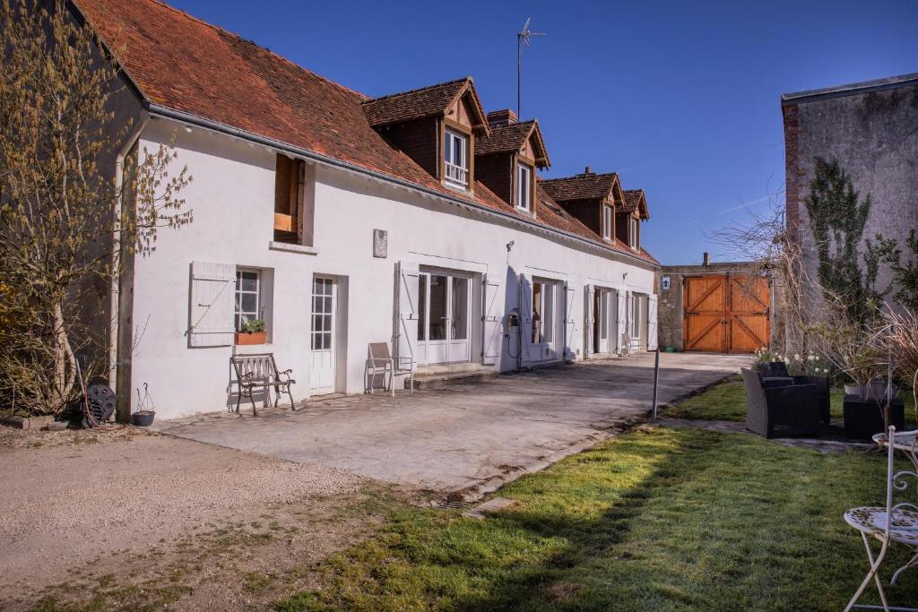 a white house with a yard and a driveway at Chambres D'hôtes Le Petit Puits in Cheverny