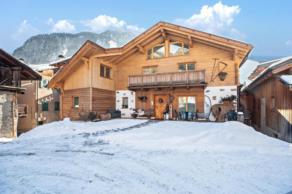 a large wooden house in the snow at Chalet Osmar Suite 2 in Campitello di Fassa