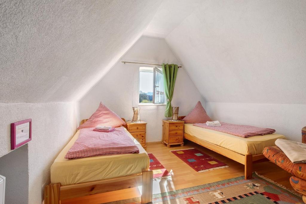 a attic room with two beds and a window at Ferienwohnung Sila 3 in Weinstadt