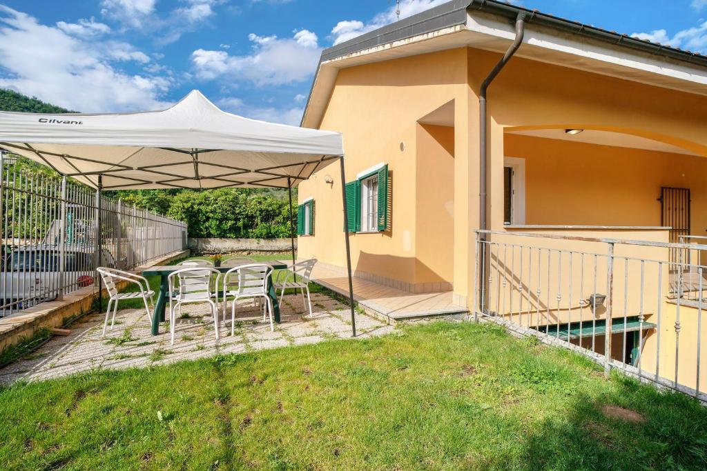 a patio with a table and chairs under an umbrella at Il Frutteto 48 in Ortovero