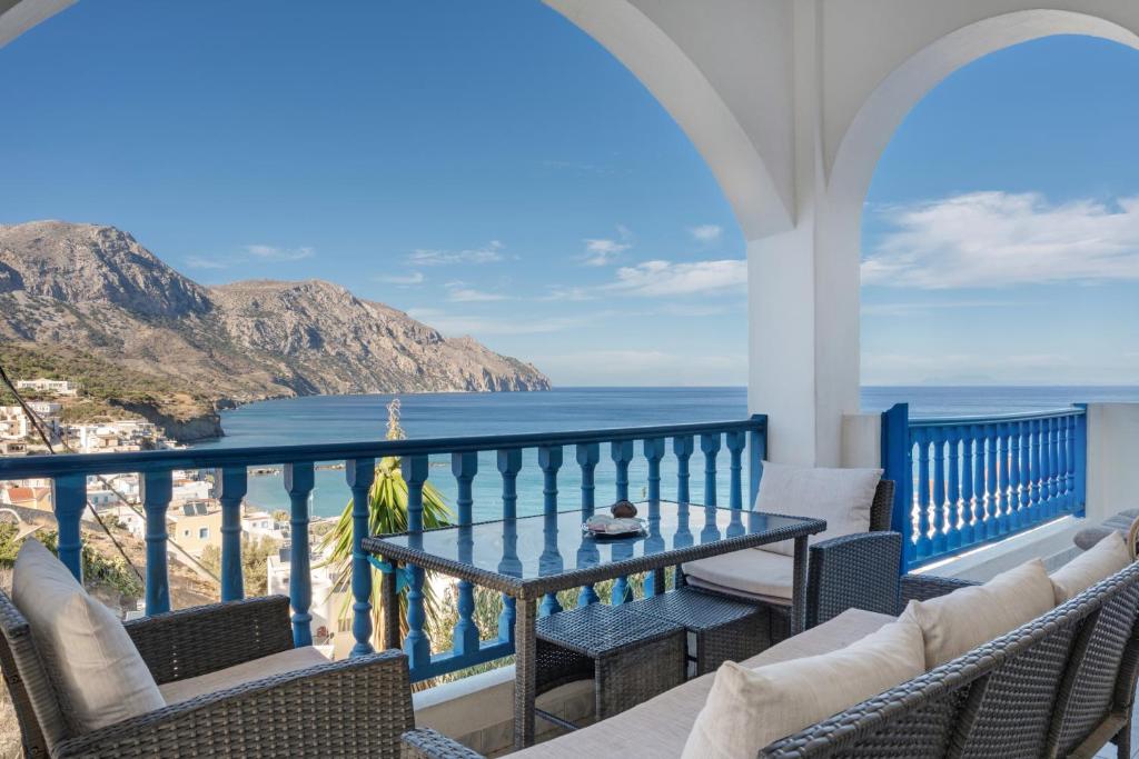 a balcony with a table and chairs and the ocean at Hotel Glaros Karpathos in Karpathos
