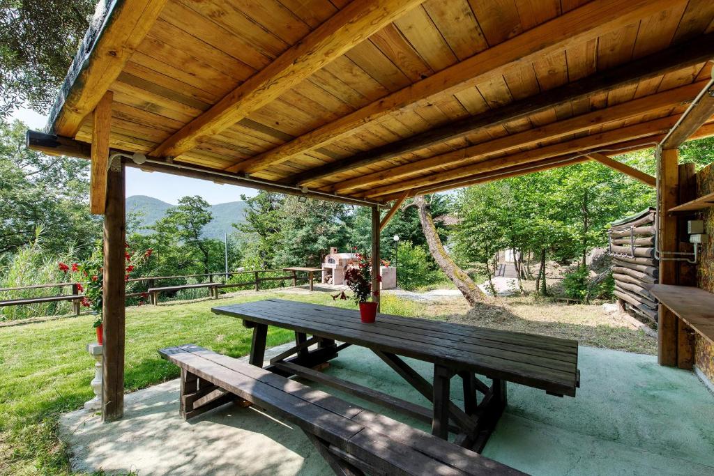 a wooden picnic table under a wooden pergola at La Liguria tra gli Ulivi 2 in Varazze