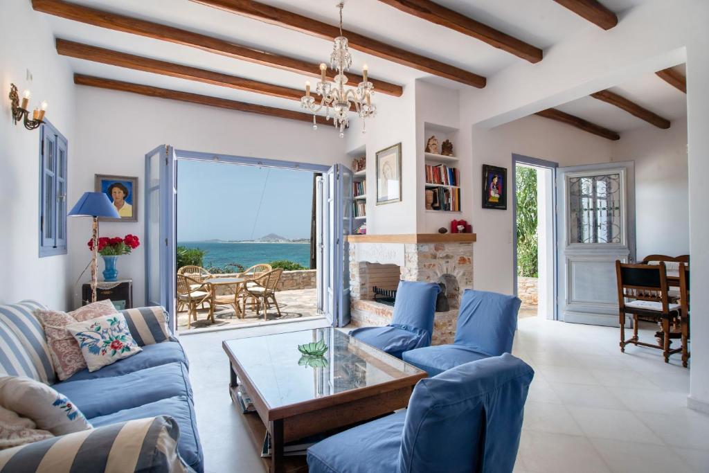 a living room with blue couches and a fireplace at Orkos View House in Naxos Chora