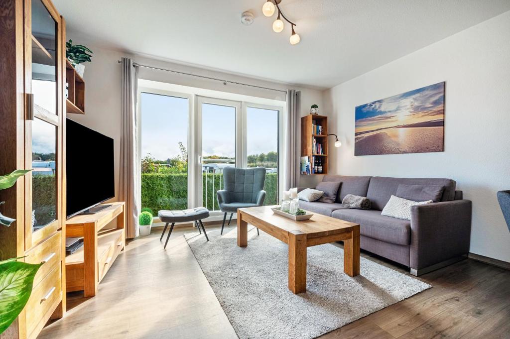 a living room with a couch and a table at Kleine Auszeit - Hohe Lith in Cuxhaven