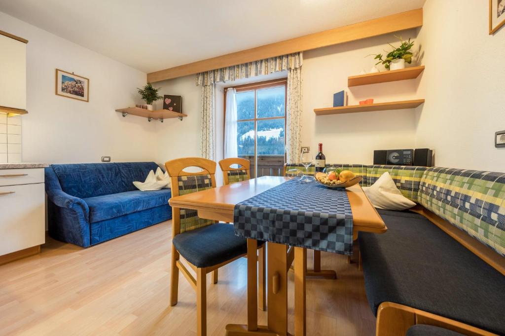 a living room with a table and a blue couch at Niederkoflhof Durreck in Cadipietra