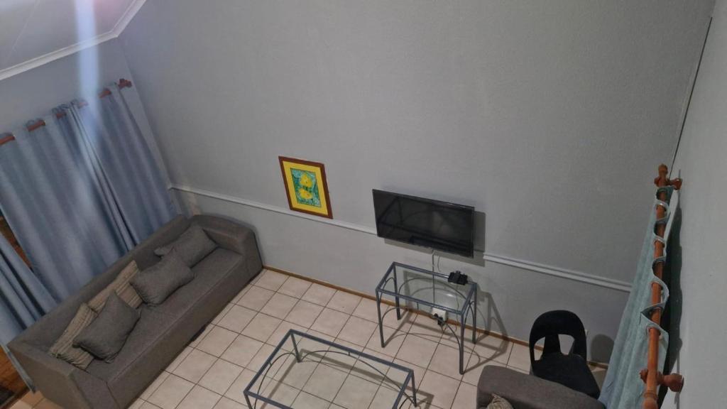 a living room with a couch and a tv at Pendleberry Unit 85 in Warmbaths