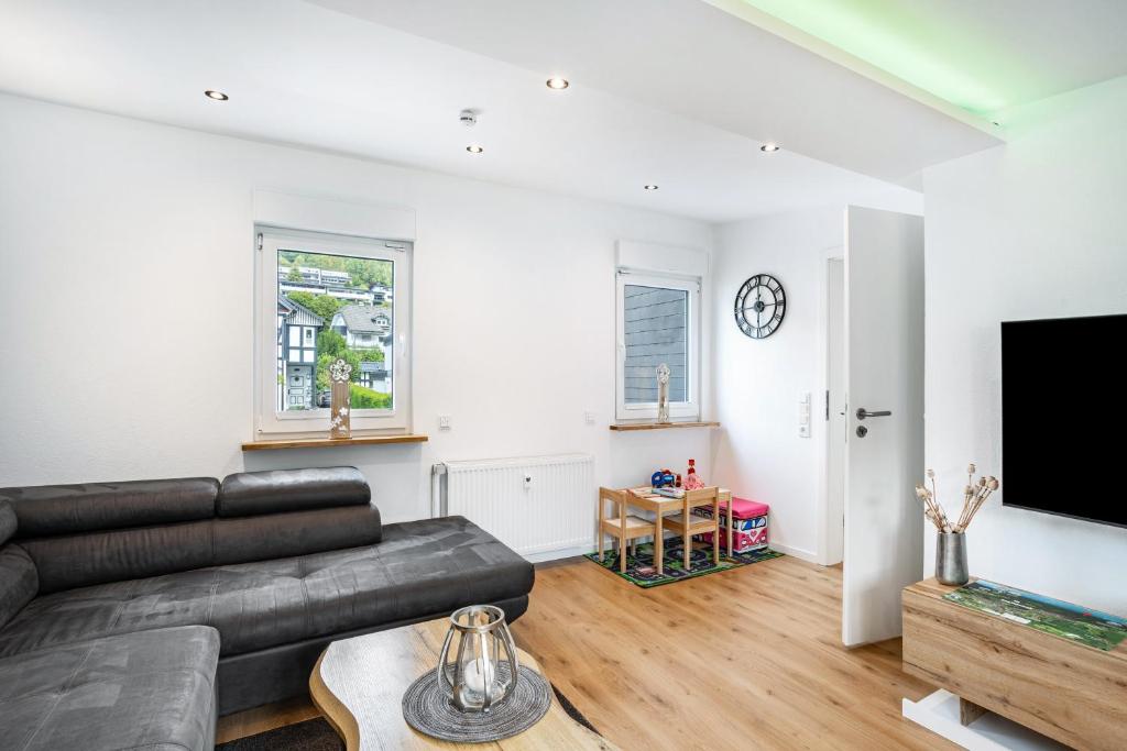 a living room with a couch and a tv at Ferienwohnung Kurparkblicksauerland in Lennestadt