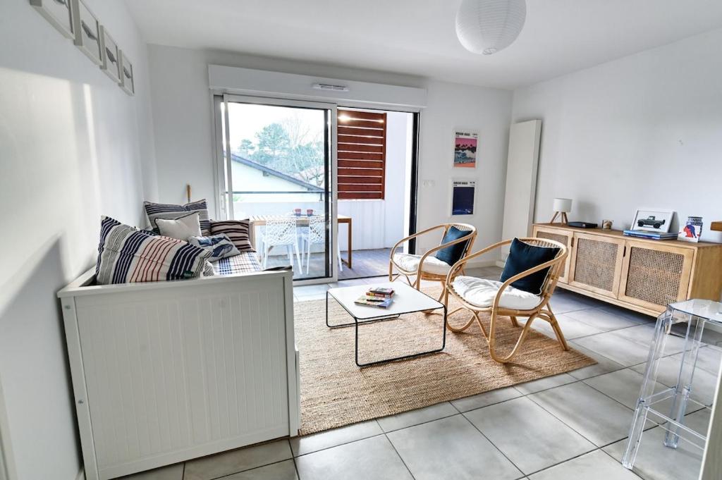 a living room with a couch and chairs and a table at Senyo Cocoon in Seignosse
