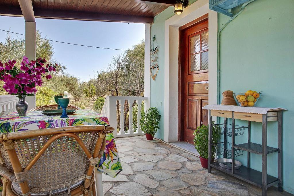 a table and chairs on a patio with a door at Areti Orfeas Apartment 7 in Vasilikos