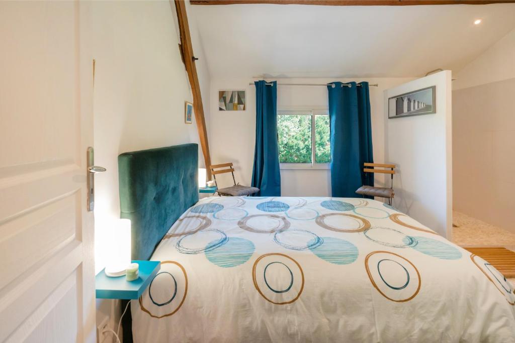 a bedroom with a large bed with blue curtains at Chambre Chene in Mauléon-dʼArmagnac