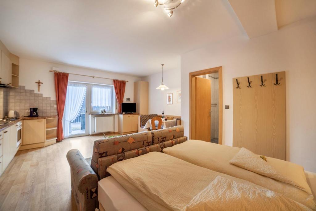 a bedroom with a large bed and a kitchen at Residence Pichler Apartment 7 in San Leonardo in Passiria