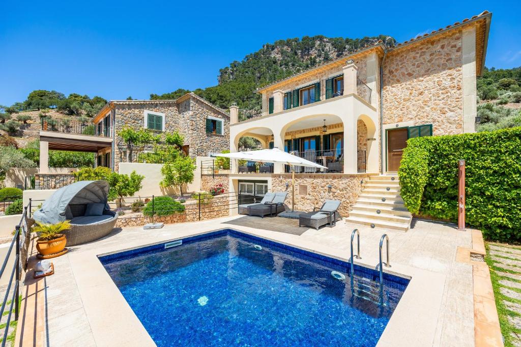 a villa with a swimming pool in front of a house at Sa Papaiona in Valldemossa