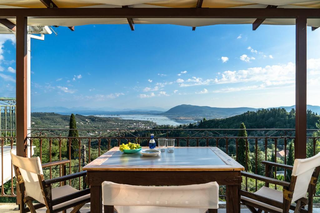 a table and chairs on a balcony with a view at Afroksilia Villa Gardenia in Lefkada