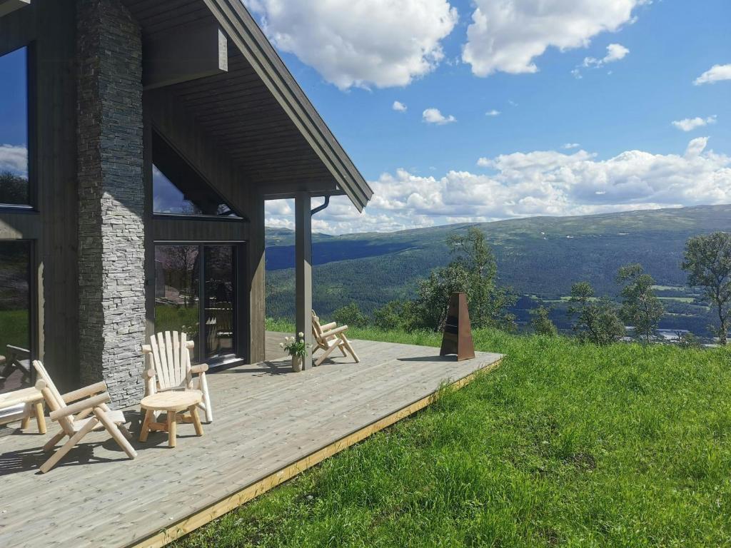 a wooden deck with chairs on top of a house at Mountain Cabin With Panoramic Views And Sauna in Oppdal