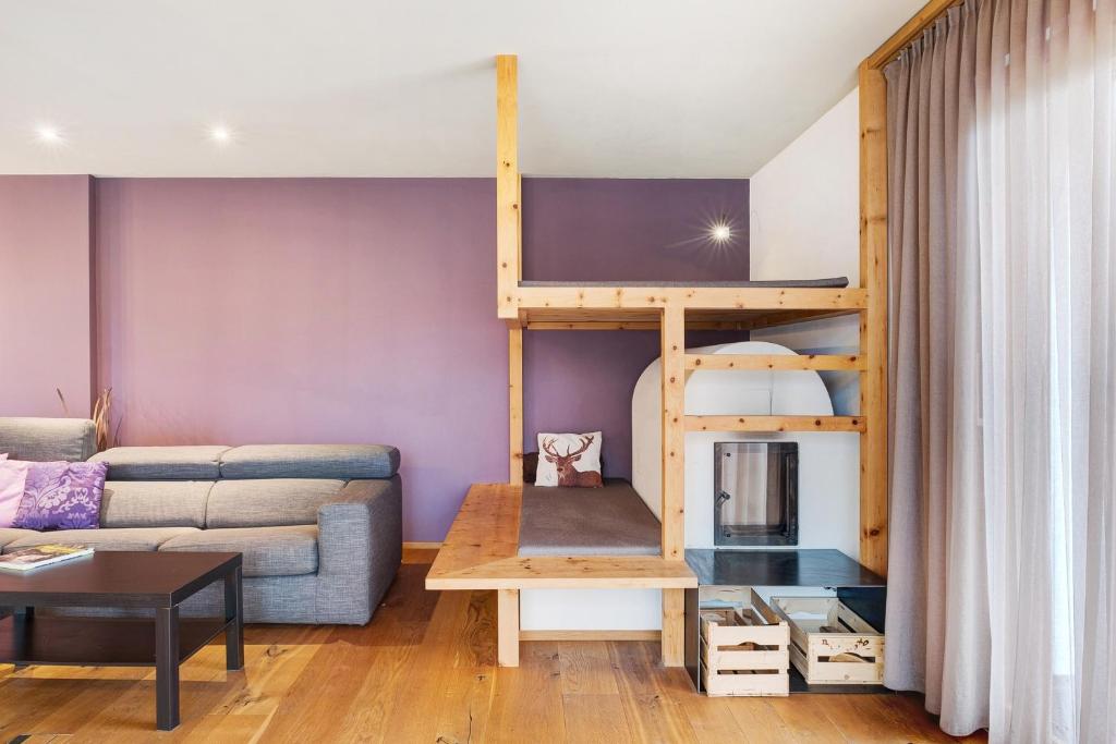 a living room with a couch and a bunk bed at Angerle Alm Apt Alpenglühen in Carezza al Lago