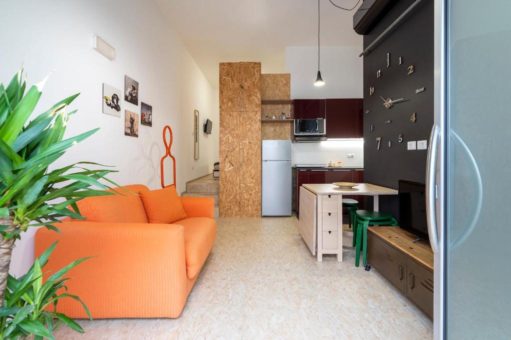 a living room with an orange couch and a kitchen at La Casa di Laura in Putignano