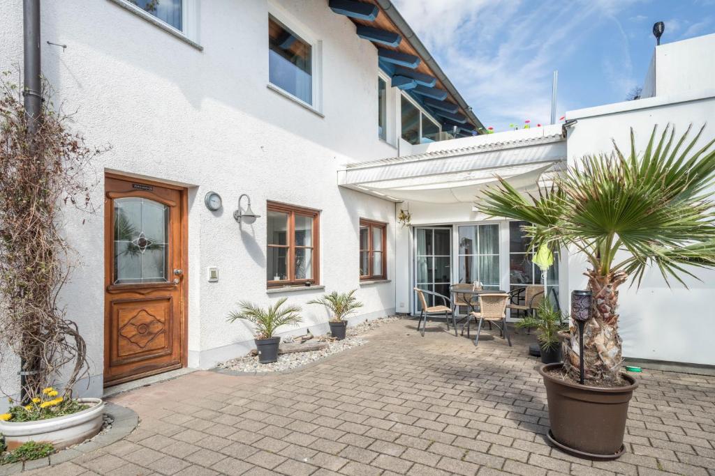 a courtyard of a white house with potted plants at Ferienwohnung Relax in Sigmarszell