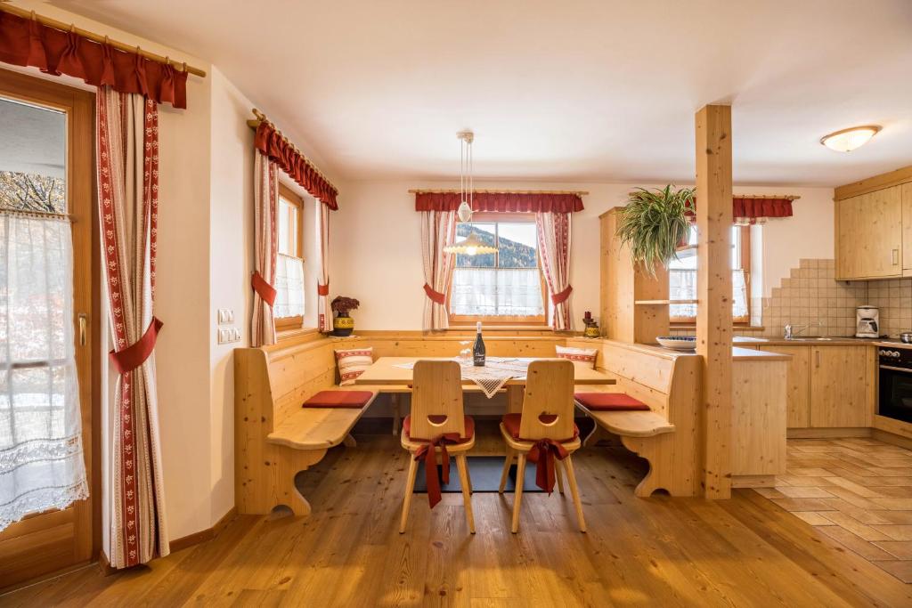 a kitchen with a wooden table and chairs at Ciasa Tlara App Lisa in San Vigilio Di Marebbe