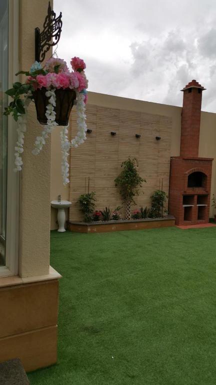 a building with a yard with green grass and flowers at فلل لوسيرن in Khamis Mushayt