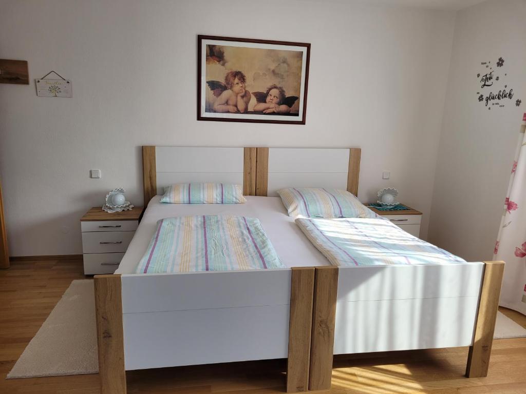 a bed in a bedroom with a picture on the wall at Ferienwohnung bei Helga in Tittmoning