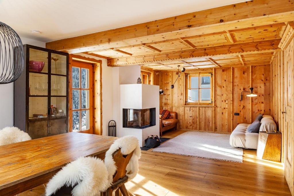 a living room with wooden walls and wooden floors and a table at Chalet Flocke Sternschnuppe in Sankt Anton am Arlberg