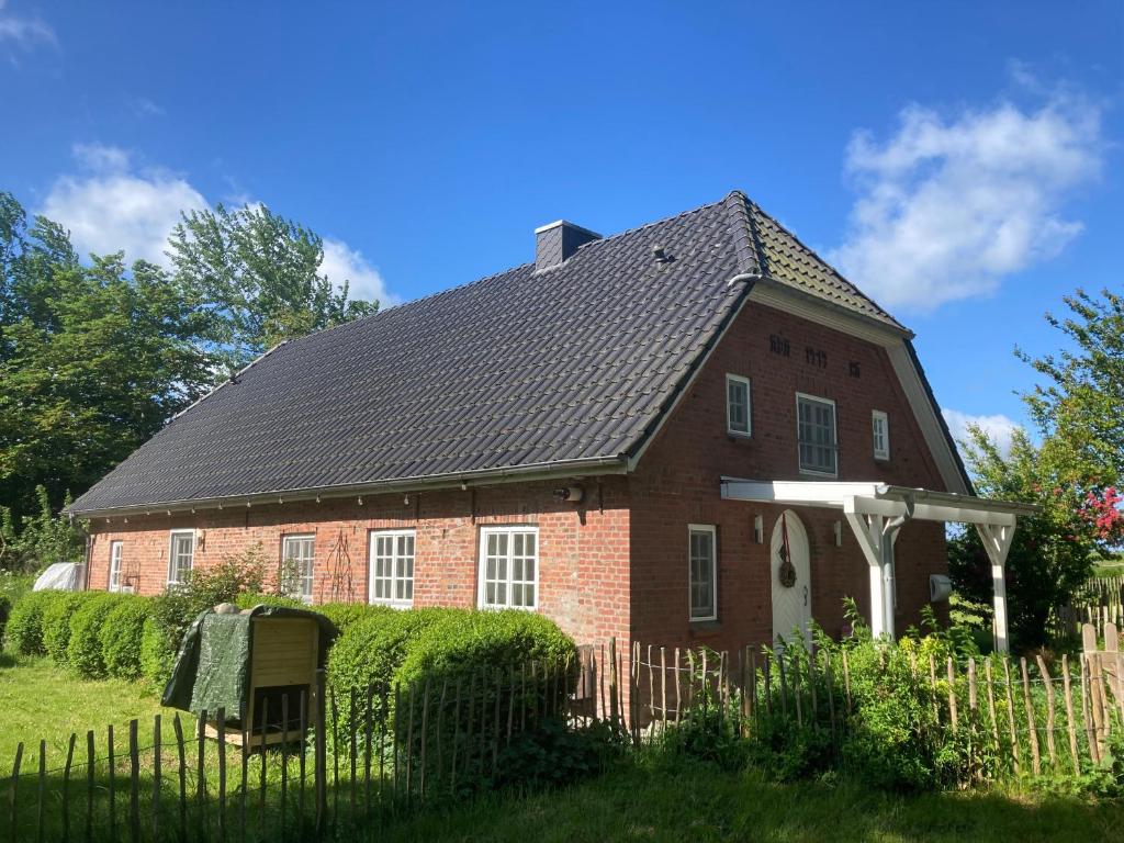a red brick house with a black roof at Landhaus Sommerland in Uelvesbüll