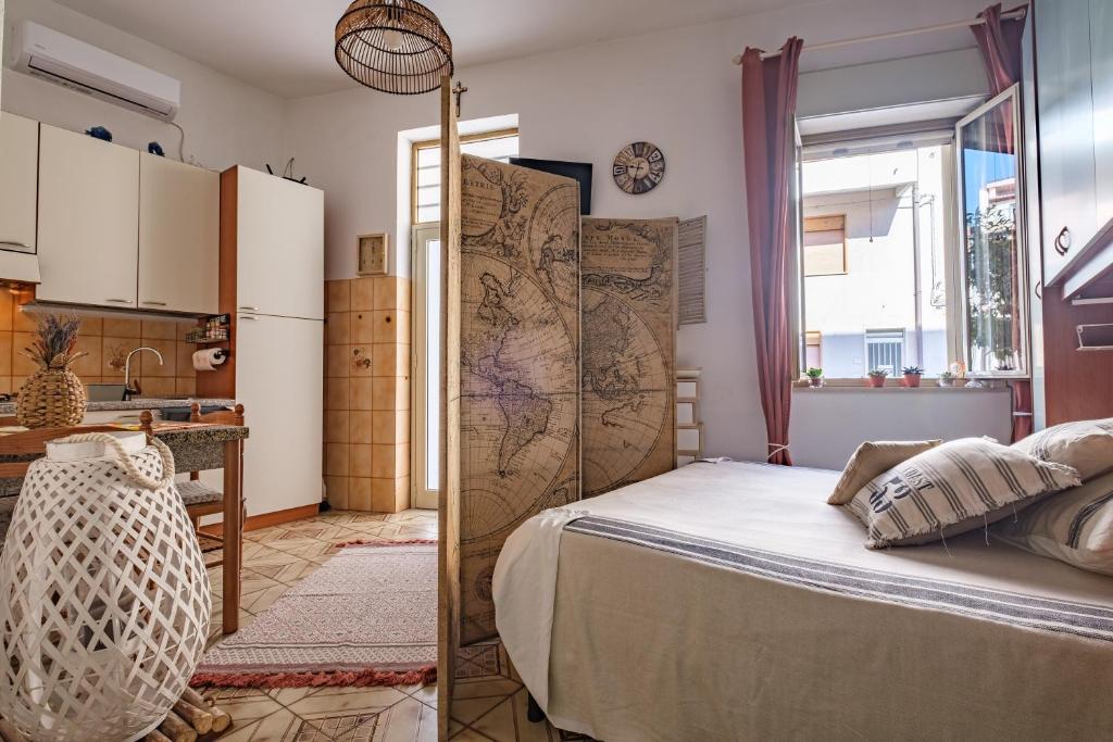 a bedroom with a bed and a kitchen at Tyndaris home in Oliveri