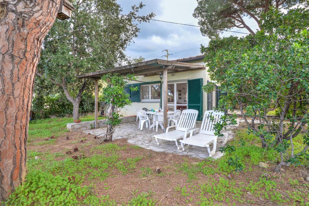 a house with a patio with chairs and a table at Villetta Serena in Procchio