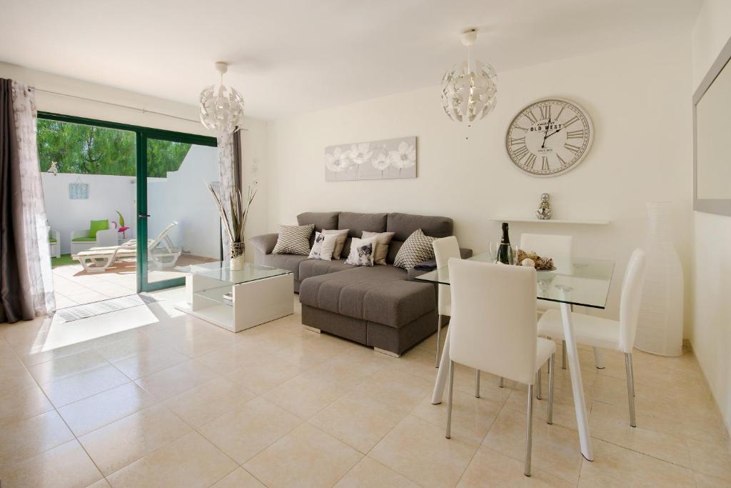 a living room with a couch and a table and a clock at Duplex vista mar in Yaiza