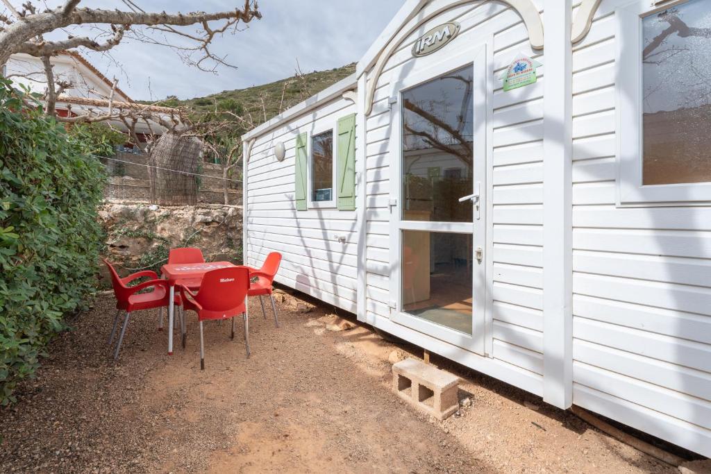 a table and chairs next to a white trailer at Falaguera Bungalow 3 in Bárig